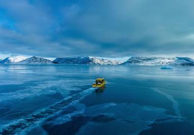 Un barco navega por una bahía con agua congelada a las afueras de Nuuk, Groenlandia.