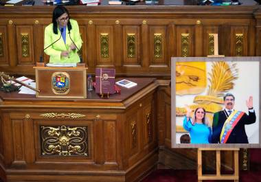La presidenta encargada de Venezuela, Delcy Rodríguez, habla ante los legisladores junto a una foto del expresidente Nicolás Maduro y su esposa Cilia Flores, en la Asamblea Nacional en Caracas, Venezuela.