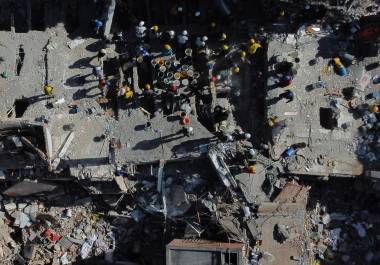 Voluntarios y rescatistas utilizan cubos para retirar los escombros de un edificio derrumbado un día después de un sismo que remeció Cali, Colombia, el 11 de agosto de 2026.
