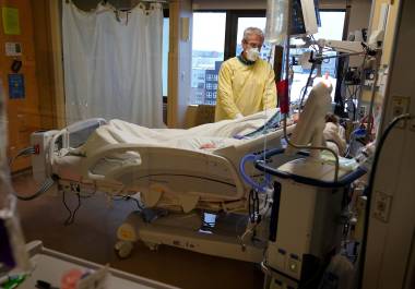 Steve Grove, capellán del Centro Médico del Condado Hennepin, ora en el cuarto de un paciente con COVID-19, el 10 de diciembre de 2021, en Minneapolis.