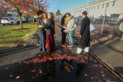 Inmigrantes de Portland, incluido Victor Cruz, en el centro a la derecha con la sudadera gris, abrazan a familiares tras ser liberados bajo fianza en Tacoma, Washington, el viernes 7 de noviembre de 2025.