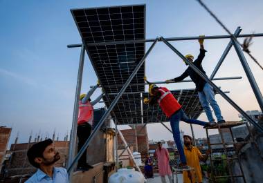 Varios trabajadores instalan paneles solares en el techo de una casa en Prayagraj, India, el lunes 14 de octubre de 2024.