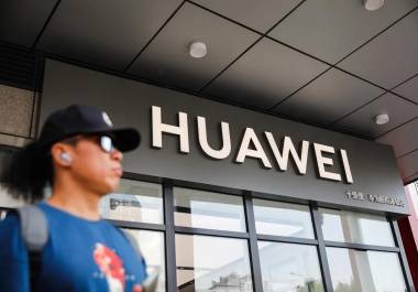 Un hombre junto a una tienda de Huawei, en Pekín, China. La compañía china es uno de los primeros blancos de Washington en una disputa comercial que inició durante el primer mandato de Donald Trump.