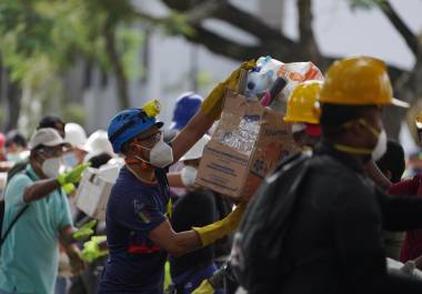 Los rescatistas distribuyen paquetes de alimentos a los equipos de rescate y voluntarios que buscan entre los escombros cuatro días después del terremoto.