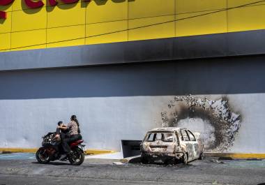 Un auto quemado junto a un negocio dañado, un día después de que el ejército mexicano matara a Nemesio Oseguera Cervantes, conocido como El Mencho, en Guadalajara, Jalisco.