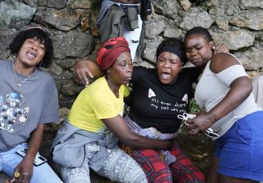 Varias mujeres se lamentan en el lugar donde sus familiares fueron asesinados durante un ataque de pandillas en el barrio de Kenscoff, el lunes 24 de agosto de 2026, en Puerto Príncipe, Haití. (AP Foto/Odelyn Joseph)