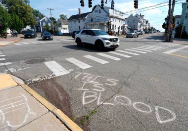 Se observa sangre en el pavimento cerca del lugar de un tiroteo en el que estuvo involucrado el Servicio de Inmigración y Control de Aduanas de Estados Unidos, el lunes 13 de julio de 2026 en Biddeford, Maine. La frase en el piso reza: Esto es sangre.