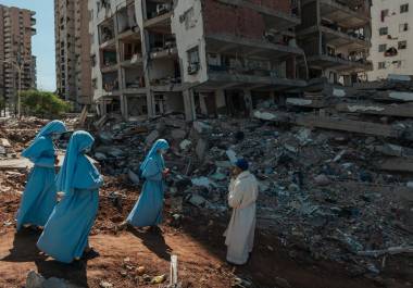 Un sacerdote y unas monjas bendecían los escombros de un edificio derrumbado en Catia La Mar, Venezuela.
