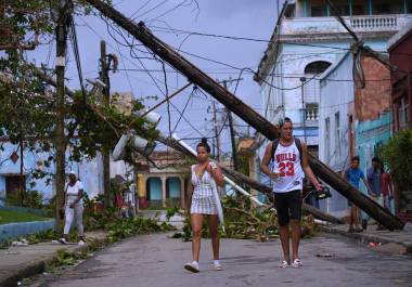 Peatones caminan en Santiago de Cuba después del paso del huracán Melissa.