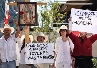 Manifestantes vestidos de blanco avanzan por el Centro Histórico de Saltillo, portando imágenes religiosas y pancartas con consignas en contra del Gobierno Federal durante la movilización de este sábado.