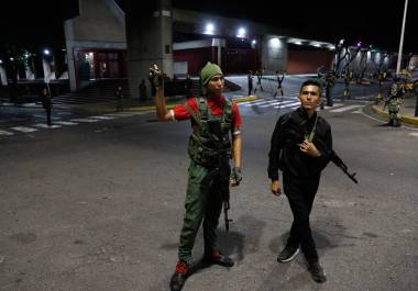 Miembros de la guardia presidencial aguardan afuera del palacio de Miraflores tras explosiones.