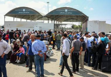 Palestinos esperan en el paso fronterizo de Rafa, tras dos años de guerra, la reapertura permitiría que miles de personas que huyeron del enclave regresen a sus hogares.