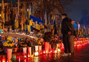 La gente enciende velas en la Plaza de la Independencia para conmemorar el cuarto aniversario de la invasión rusa de Ucrania, en Kiev, Ucrania