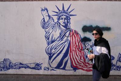 Una mujer pasa junto a un mural antiestadounidense en la pared de la antigua embajada de Estados Unidos, ahora museo, en Teherán, Irán, el viernes 12 de junio de 2026.