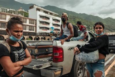 Michell Mendoza, de 16 años, a la derecha, de pie junto a un camión que llevaba el ataúd de su madre después de que le negaran la entrada a un cementerio.