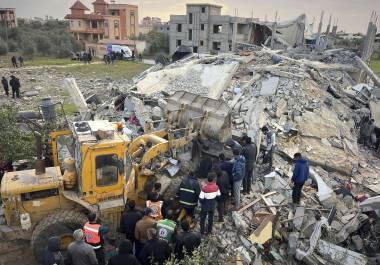 Voluntarios y rescatistas utilizan una topadora para retirar escombros de un edificio golpeado por un ataque aéreo israelí en Jan Yunis, en el sur de la Franja de Gaza, el jueves 20 de marzo de 2025. (AP Foto/Mariam Dagga)