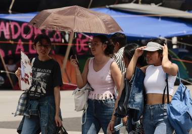 Varias personas caminan con sombrilla para protegerse del sol en Ciudad de México. La tercera ola de calor del año en México traerá temperaturas por encima de los 45 grados en casi la mitad de los estados del país.