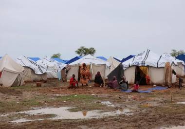 Personas sentadas cerca de sus tiendas de campaña en un campamento para personas desplazadas en Al-Huri, ciudad de Gedaref, al este de Sudán.
