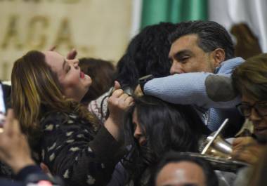 Yuriri Ayala, diputada local de Morena; toma del pelo a Daniela Álvarez, diputada del PAN, mientras que Jesús Sesma, diputado del PVEM, intenta separarlas durante el zafarrancho que se armó en la tribuna del Congreso de la Ciudad de México.