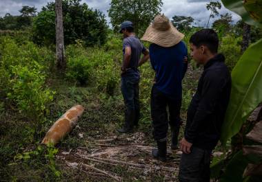 Unos hombres inspeccionan los restos de una bomba sin explotar de 227 kilogramos que cayó en una finca de la región de Putumayo, en el sur de Colombia.