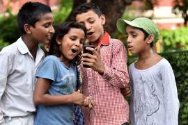 Niños en la Escuela San Columba en Delhi, India, se toman fotos con su smartphone.