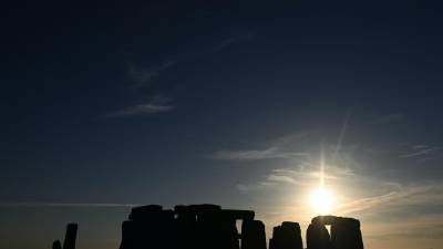 El sol se pone durante las celebraciones del solsticio de verano en el antiguo monumento de Stonehenge en Wiltshire, Gran Bretaña.