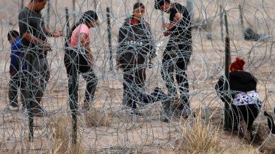 Migrantes intentan cruzar la cerca de alambres en la frontera que divide a México de los Estados Unidos, el 8 de febrero de 2024, en Ciudad Juárez, México.