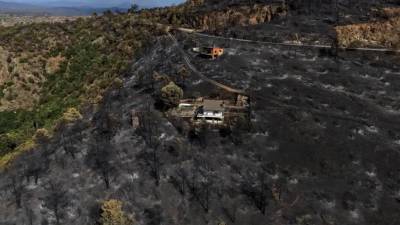 Un área arrasada por un incendio forestal rodea estructuras en El Tiemblo, provincia de Ávila, España, el jueves 30 de julio de 2026.