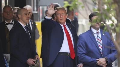 El expresidente Trump saluda a sus seguidores al salir de la Torre Trump, en camino a la Corte Criminal de Manhattan.