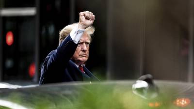 El expresidente Donald Trump alza el puño al salir de la Trump Tower para dirigirse a la oficina de la procuradora general de Nueva York para declarar en una investigación civil de sus negocios inmobiliarios.