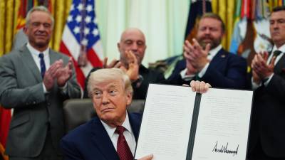El presidente de Estados Unidos, Donald Trump, sostiene una orden ejecutiva firmada en la Oficina Oval de la Casa Blanca, este sábado.