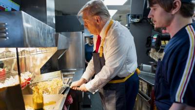 El candidato presidencial republicano, el ex presidente Donald Trump, a la izquierda, usa una freidora mientras un empleado observa durante una visita a McDonald’s en Feasterville-Trevose, Pensilvania.