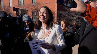 La líder opositora venezolana María Corina Machado saluda a sus simpatizantes en la Avenida Pensilvania, cerca de la Casa Blanca, tras reunirse con el presidente Donald Trump. FOTO: AP.