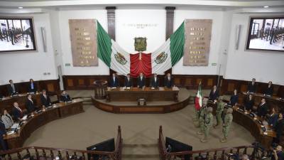 Manolo Jiménez Salinas, quien es flanqueado por los titulares de los poderes Legislativo y Judicial, rinde protesta al cargo de Gobernador Constitucional de Coahuila