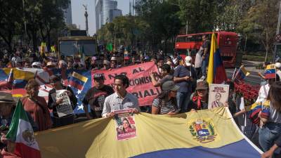 Manifestantes en la Ciudad de México sostienen banderas de Venezuela y pancartas en apoyo a la presidenta Claudia Sheinbaum, rechazando cualquier intento de intervención militar extranjera bajo el lema “México no se toca”.