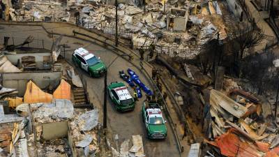 La policía recupera los cuerpos de las personas fallecidas tras los incendios forestales que arrasaron viviendas cerca de Lirquen, Chile, el domingo 18 de enero de 2026.