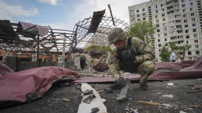 Un militar ucraniano inspecciona el lugar del ataque en la ciudad de Járkov.