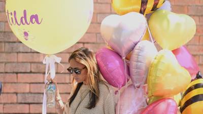 Una mujer lleva globos al funeral de Matilda, de 10 años, víctima del tiroteo masivo en Bondi Beach, cuyo apellido se mantiene en reserva a petición de su familia, en Sídney.