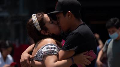 Una pareja se besa y abraza apasionadamente en la Glorieta de los Insurgentes en CDMX.