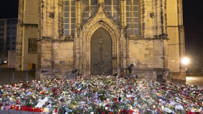 Velas, flores y guirnaldas frente a la entrada de la iglesia de San Juan a primera hora del domingo 22 de diciembre de 2024, en Magdeburgo, Alemania, después de que un coche arrollara a una multitud en un mercado navideño el viernes 20 de diciembre.