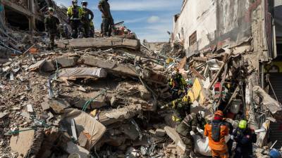 Los rescatistas sacan el cuerpo de una víctima de entre los escombros cuatro días después del terremoto que azotó Pereira, Colombia.
