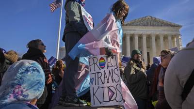 04/12/2024. Nate, de 14 años (i), y Bird, de 9 años (d)a, participan en una protesta frente a la Corte Suprema. Donald Trump prohíbe el tratamiento de transición de género y cirugías a menores de 19 años.