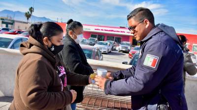 Personal de Seguridad Pública de Monclova entregando bebidas calientes en una jornada solidaria fuera del IMSS clínica 7.