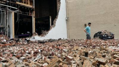 Un hombre camina entre ladrillos caídos de un edificio dañado después de una fuerte tormenta en Houston.