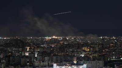 Un avión de Middle East Airlines vuela mientras se eleva humo tras los ataques aéreos israelíes en Dahiyeh, un suburbio al sur de Beirut, Líbano.