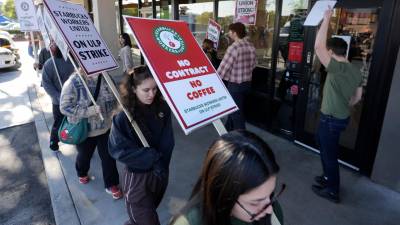 Trabajadores de Starbucks protestan frente a una de sus cafeterías, el viernes 20 de diciembre de 2024, en Burbank, California.