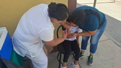 Personal del IMSS aplica vacunas a menores en módulos instalados en espacios públicos como parte de la jornada estatal.