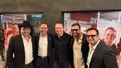 Manolo Jiménez Salinas saluda a Julión Álvarez en el Coliseo Centenario durante su informe.