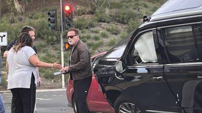 Se puede ver a Arnold Schwarzenegger en su camioneta GMC Yukon luego del percance, junto a los posibles afectados.