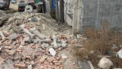 Restos de ladrillos y materiales de construcción bloquean el paso en una de las calles de la colonia Independencia.